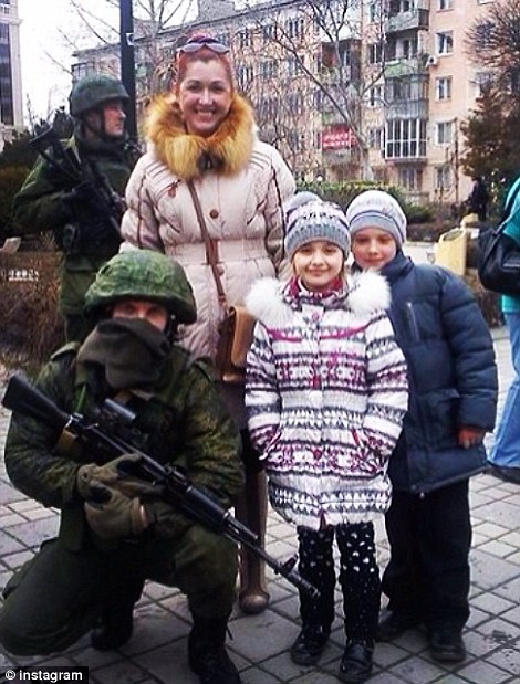 Bewoners op de Krim samen met Russische soldaten op de foto.